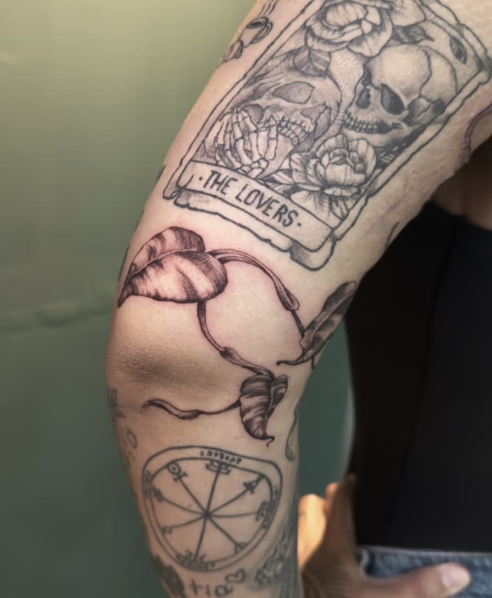 Tatuaje de hojas y carta de tarot en brazo – Cheno Tattoo Pachuca
